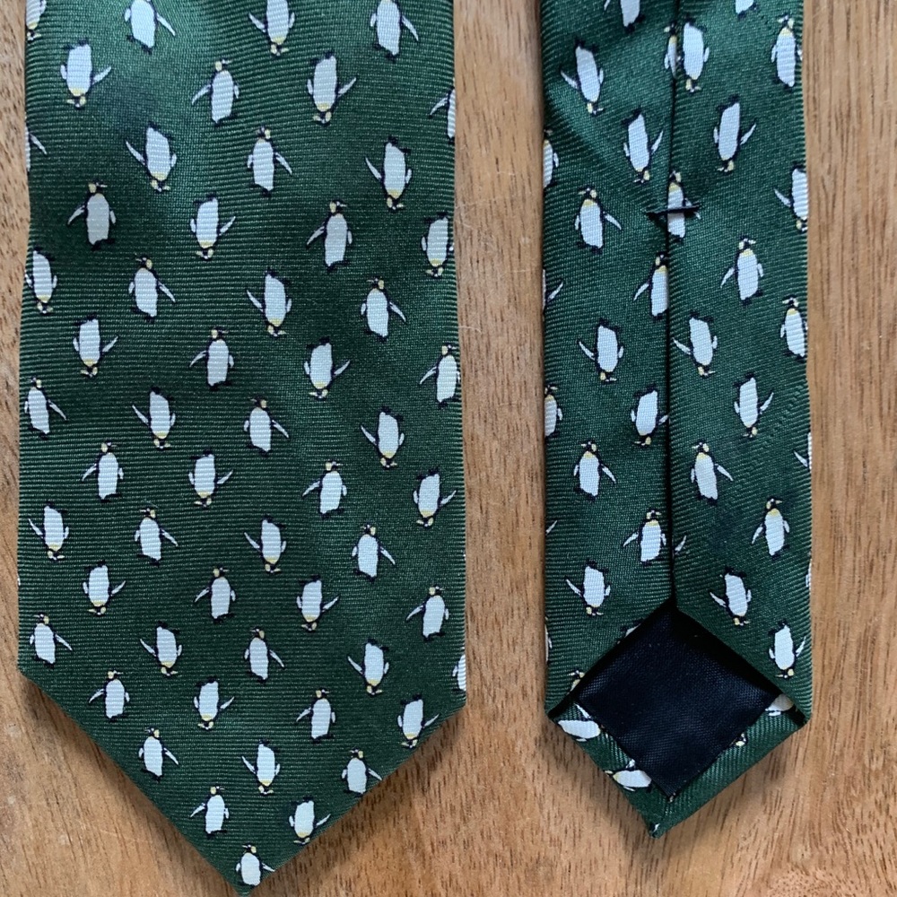 Forest green tie patterned with white penguins.